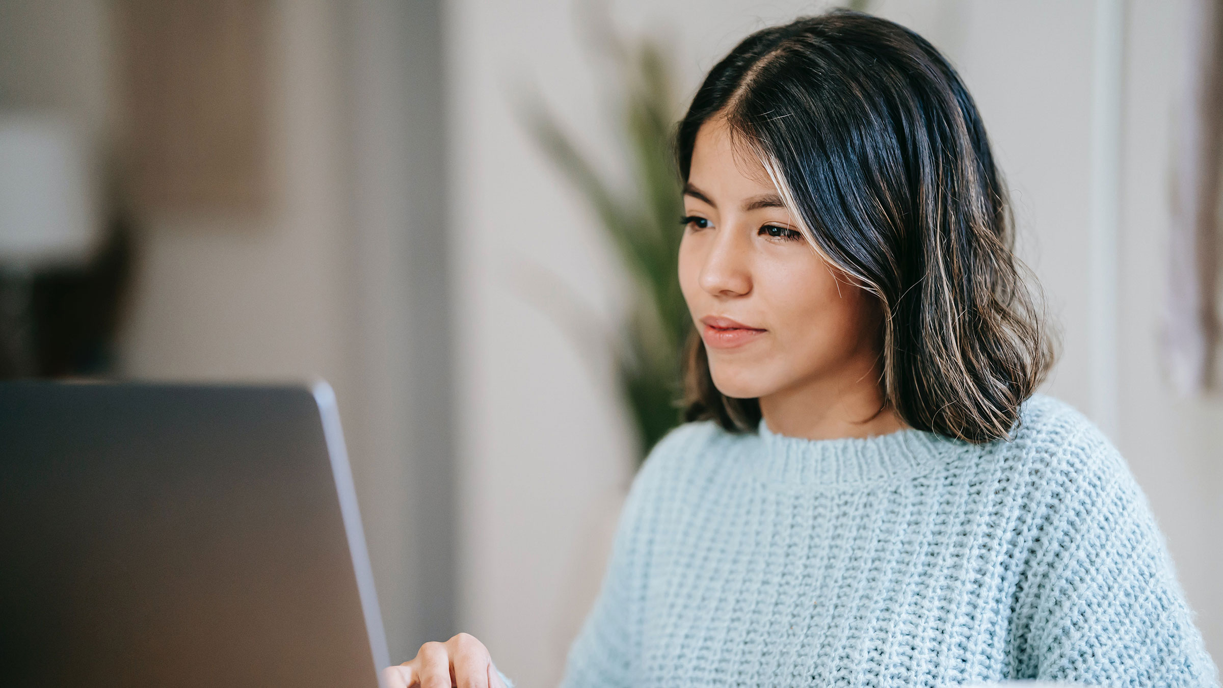 person looks seriously at laptop computer