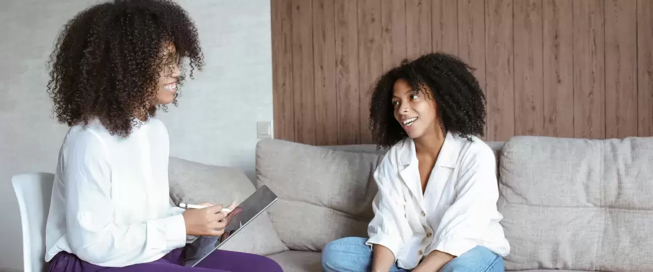 person sits on couch talking to therapist