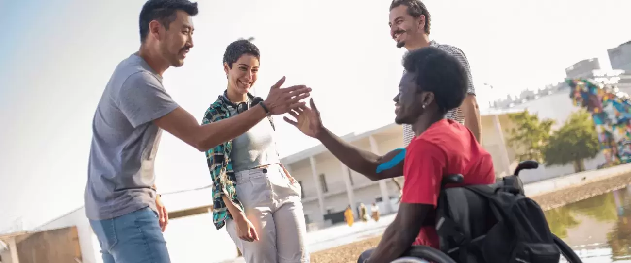 Adults and young adults stand and sit and give each other a high five